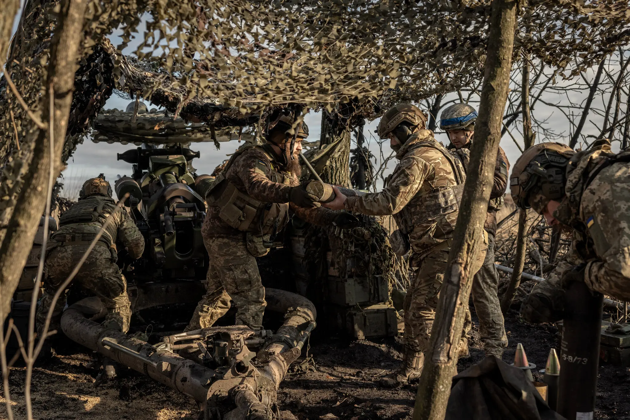 Члени української артилерії з 80-ї десантно-штурмової бригади заряджають снаряд 1 січня перед обстрілом позицій росіян у напрямку Бахмута на сході України.